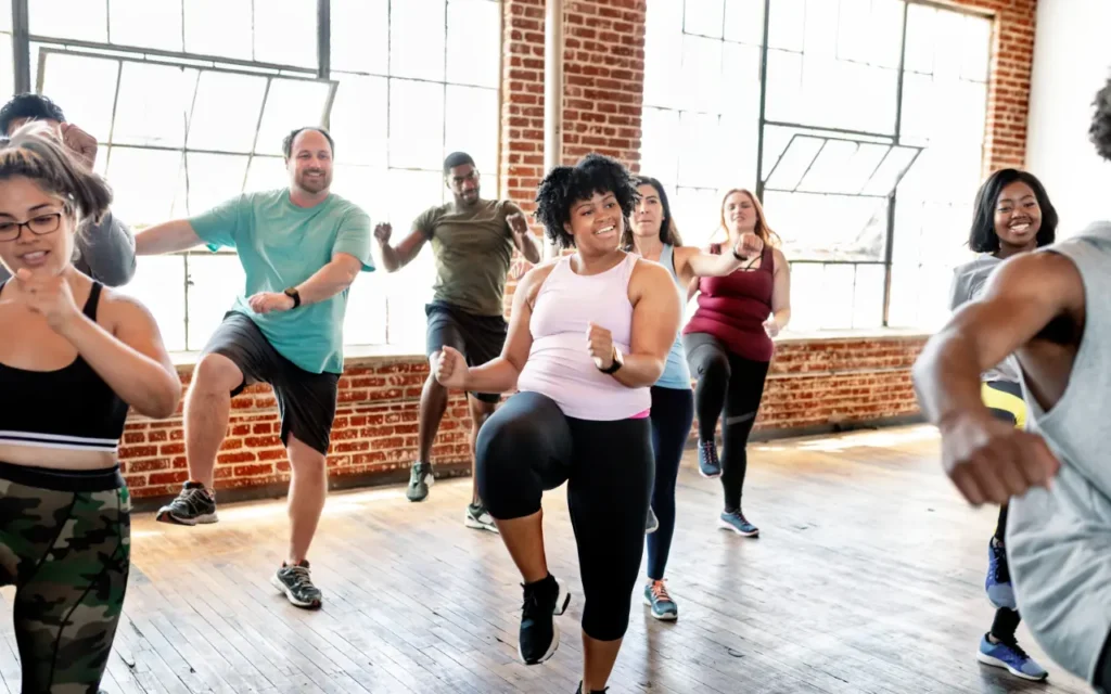Men and women in a gym taking part in an exercise class