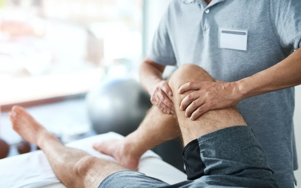 A man having his knee examined by a medical professional