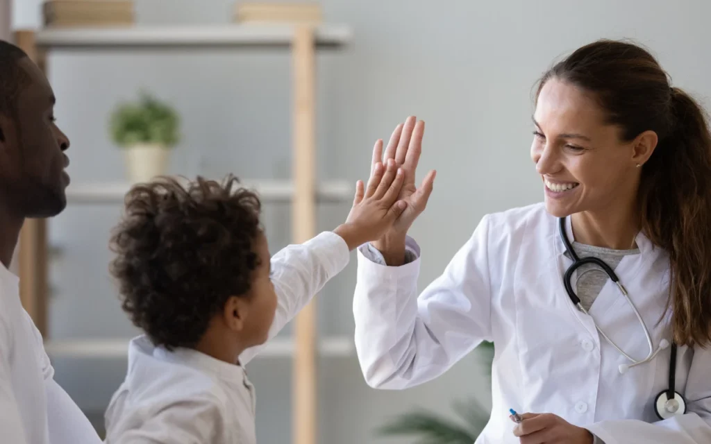 A doctor high-fiving a child