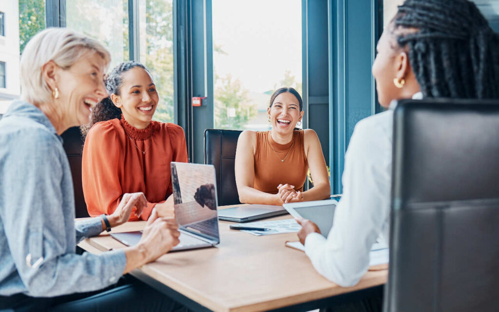 a group of women sat around a table discussing business
