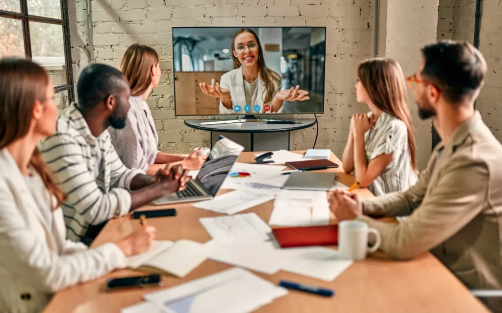 A team sitting watching a presentation on a screen in a board room