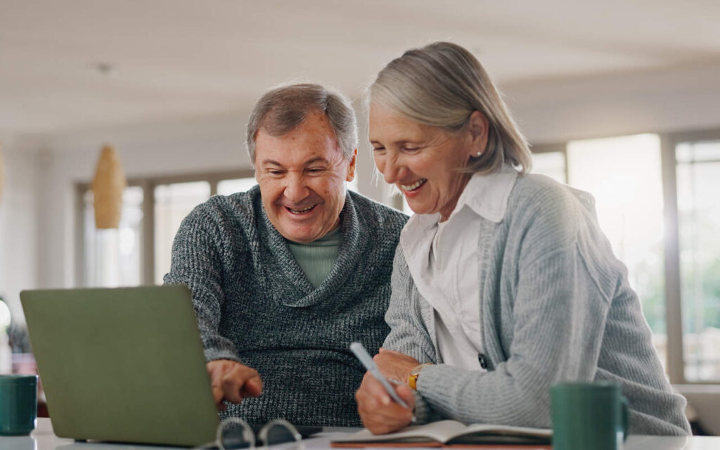 An older couple looking at a laptop